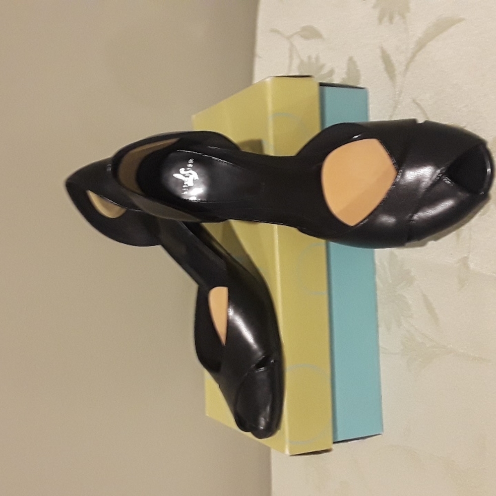 Black leather upper with black patent leather heel and peep toed.